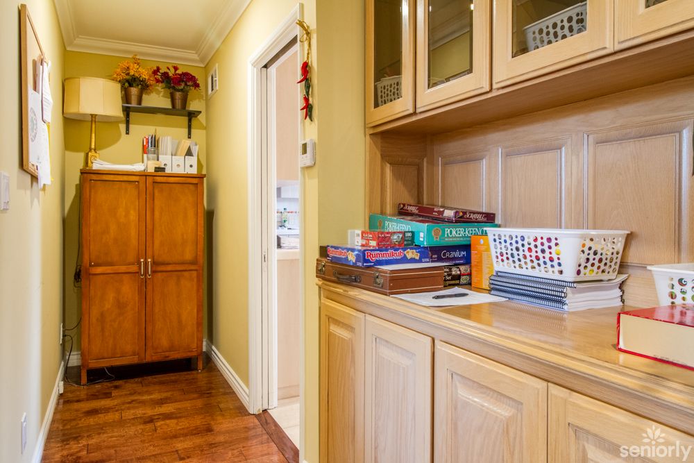 A cozy hallway featuring wooden cabinets and shelves adorned with books and decor items.
