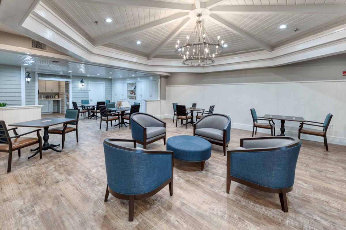 A modern lounge with comfortable seating and a chandelier in the center.