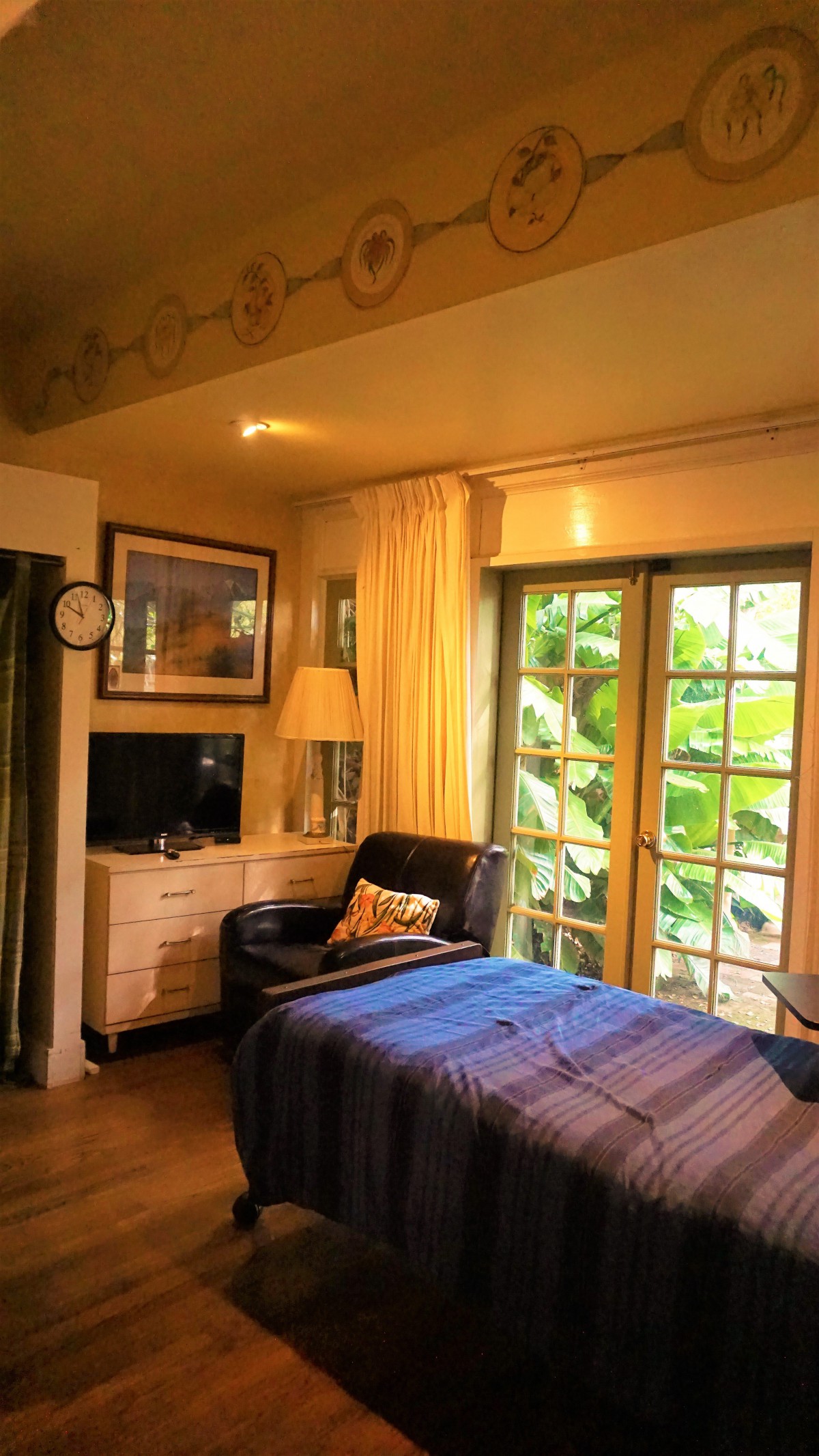 A cozy bedroom interior with natural light streaming through the windows.