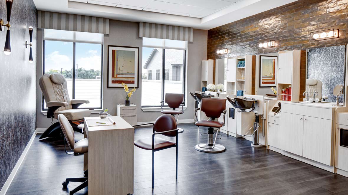 A modern hair salon interior with stylish chairs and mirrors.