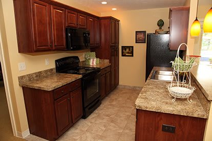 A modern kitchen with wood cabinets and marble countertops.