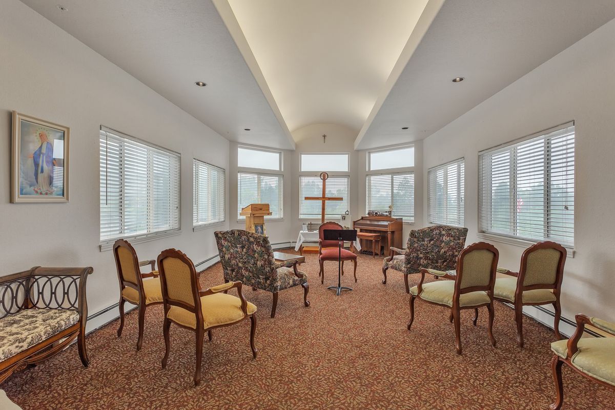 A well-lit meeting room with elegant chairs arranged in a circle, surrounded by large windows.