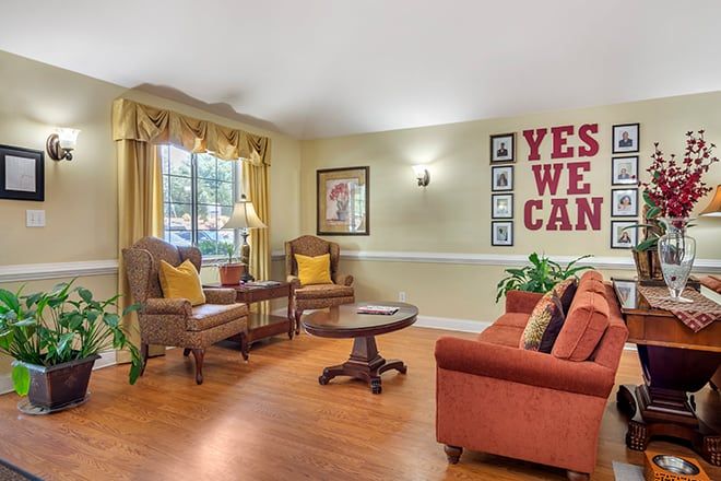 A cozy living room with comfortable seating and motivational wall art.