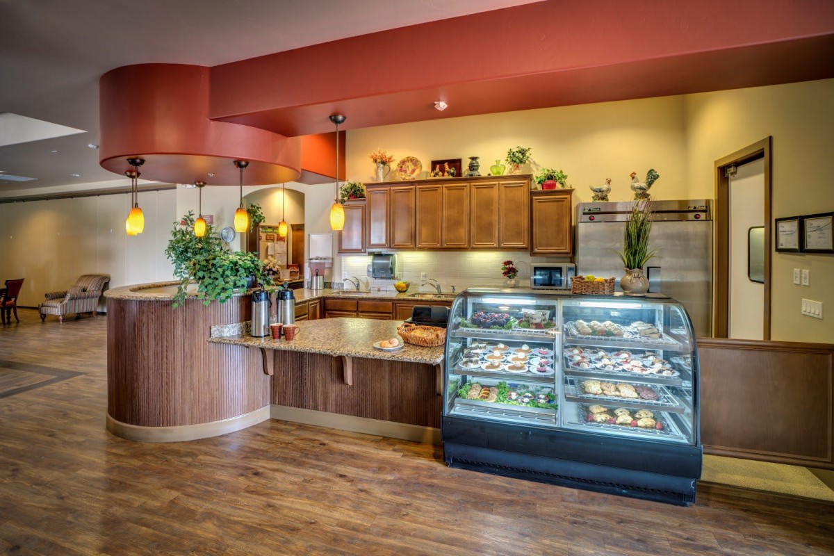 A cozy bakery and cafe with a well-lit dessert display and wooden accents.