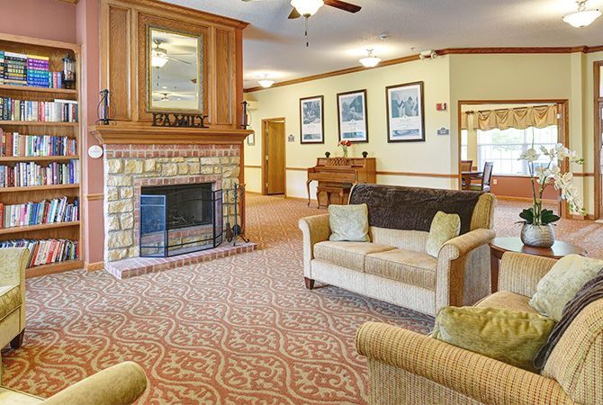 A cozy living room with a stone fireplace, comfortable couches, and elegant decor.