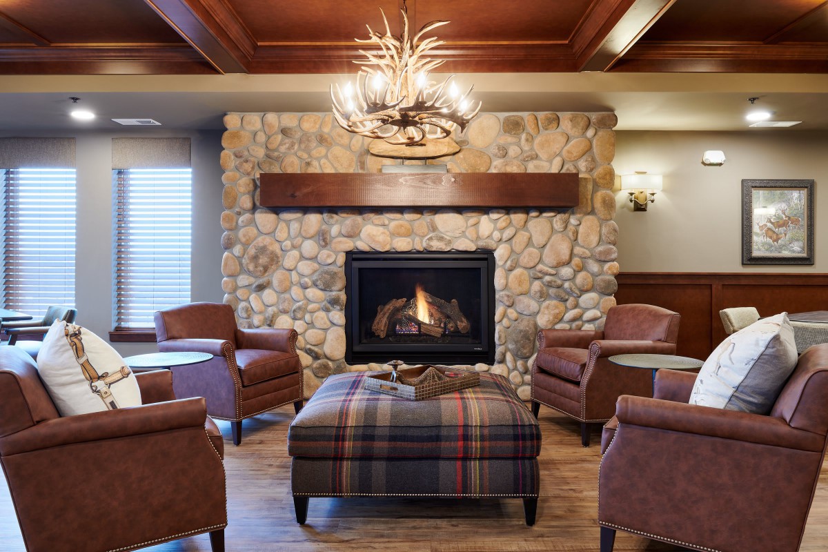 A cozy living room with a stone fireplace and comfortable armchairs.