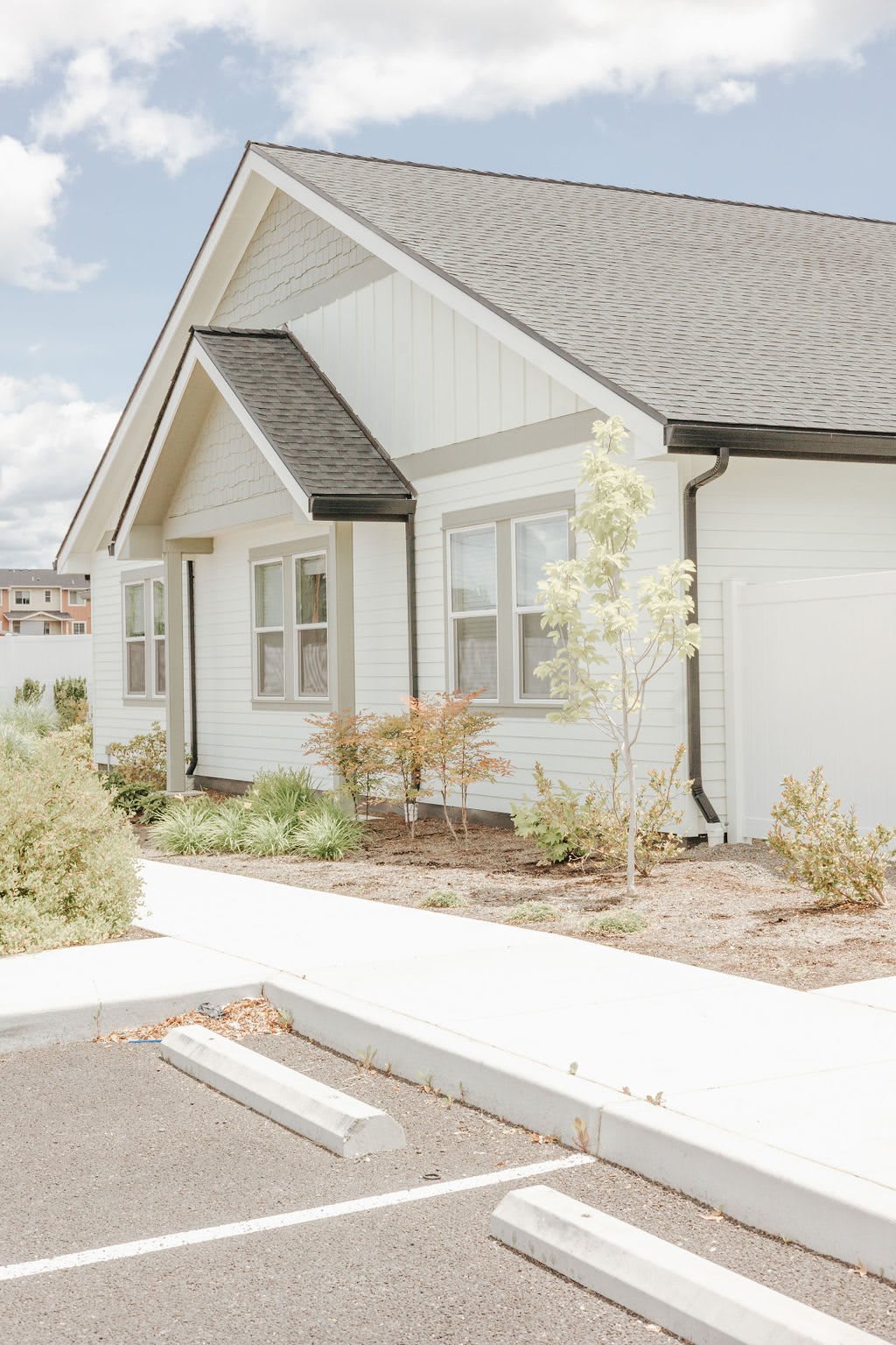 A modern suburban house with a well-maintained front yard on a sunny day.