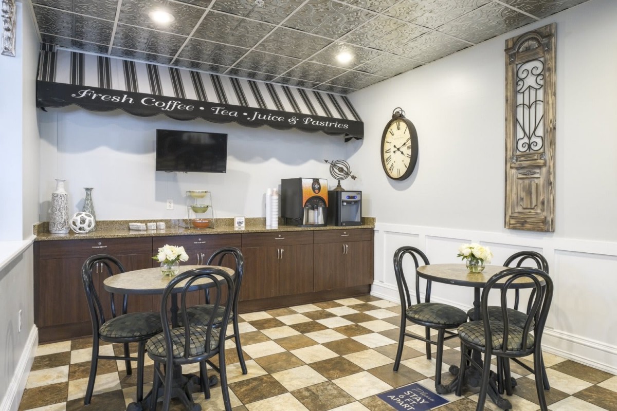 A cozy cafe interior with checkered flooring and a coffee station.