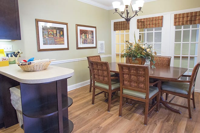A cozy dining room with wooden furniture, decorative artwork, and elegant lighting.