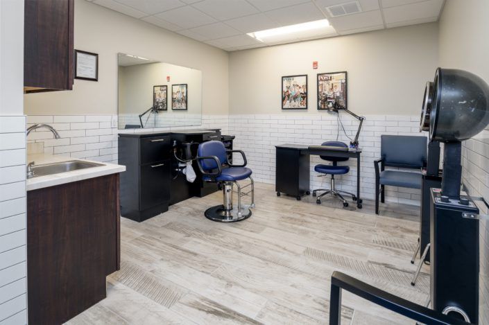A well-lit, modern hair salon interior with styling chairs and mirrors.