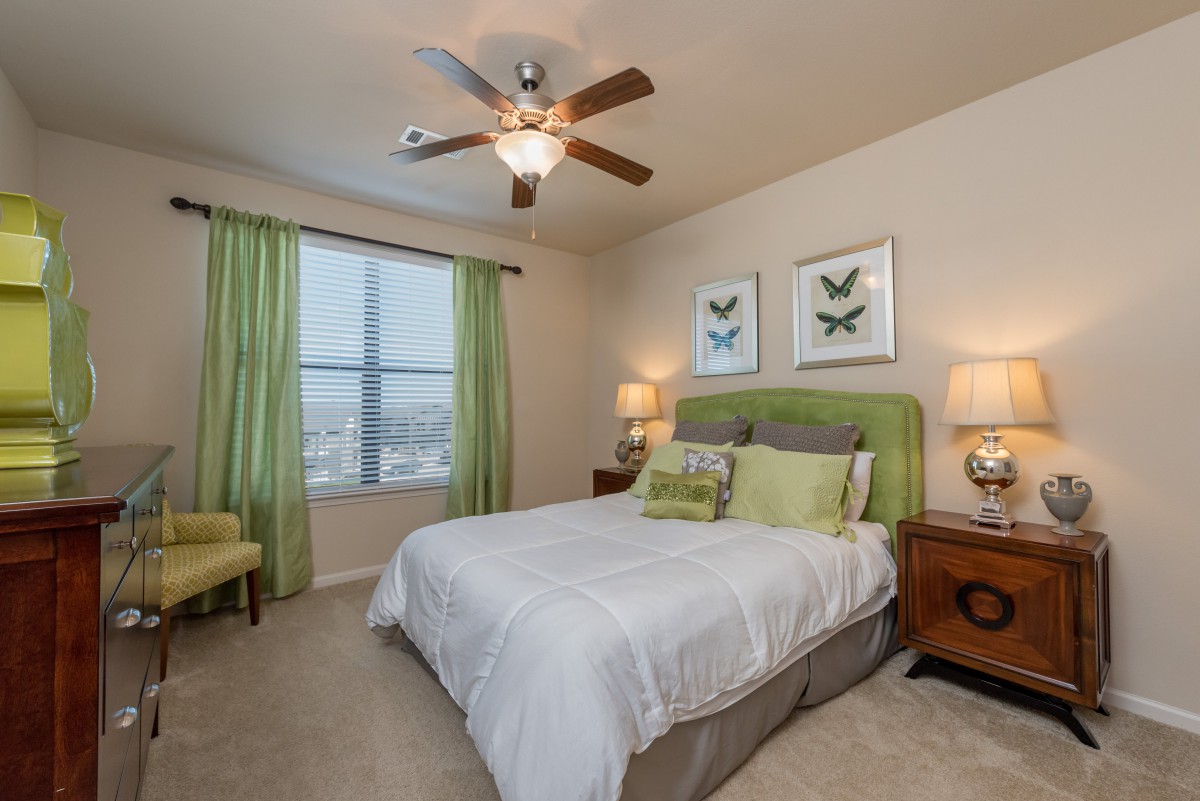 A cozy bedroom with green accents and soft lighting.
