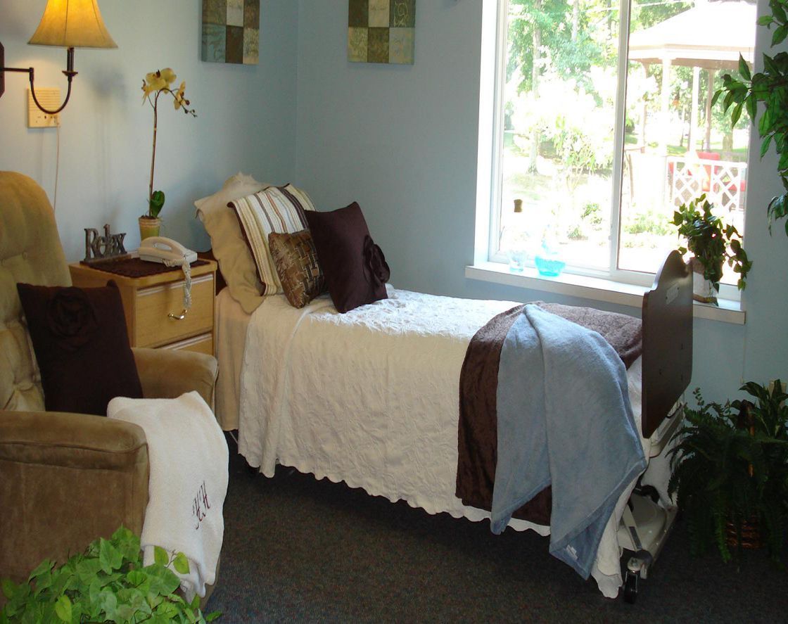 A cozy bedroom with a single bed and a large window allowing natural light in.