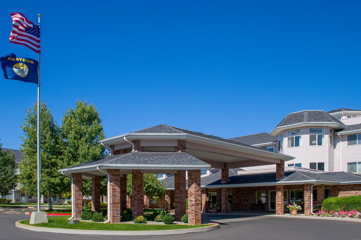 An elegant building entrance with brick columns and a clear blue sky.