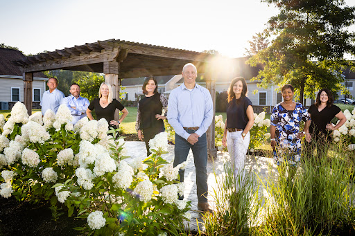 A team gathered in a sunlit garden, captured in a moment of togetherness.