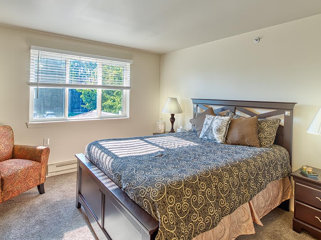 A cozy bedroom with a large bed and natural light streaming through the window.