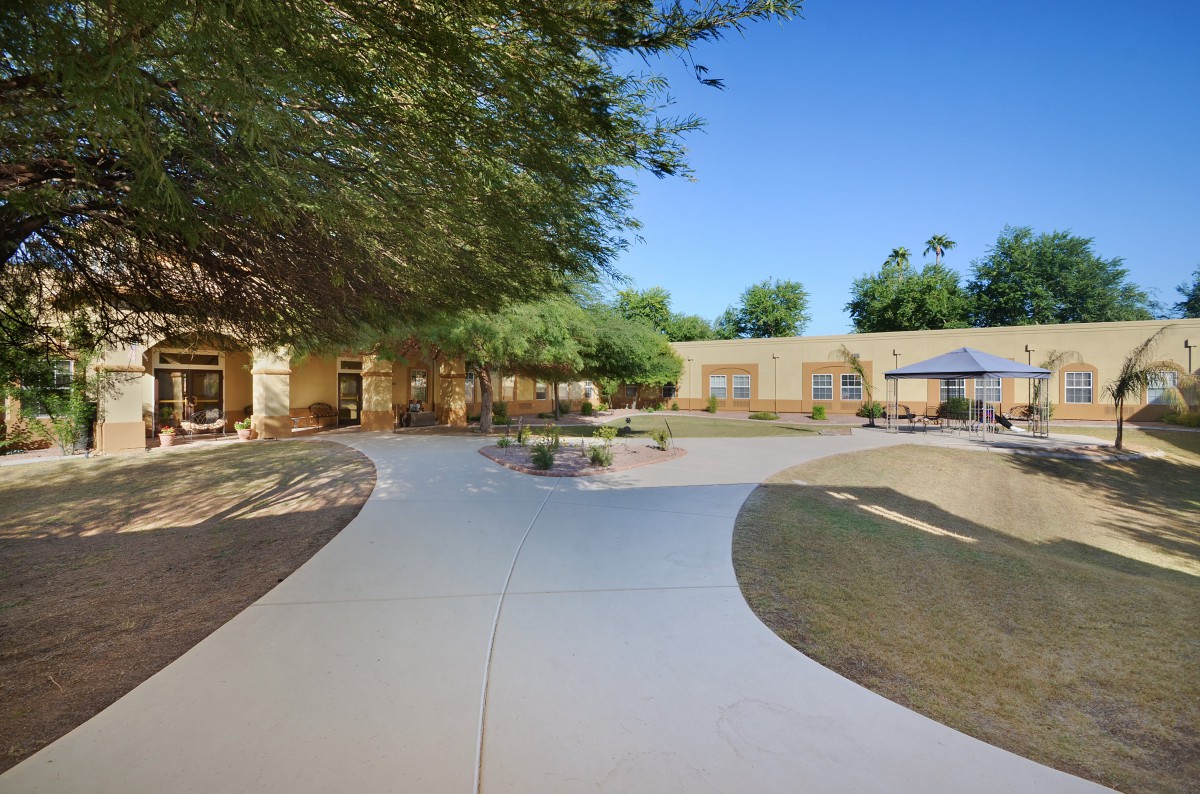 A serene outdoor relaxation area with a winding pathway and benches on a sunny day.