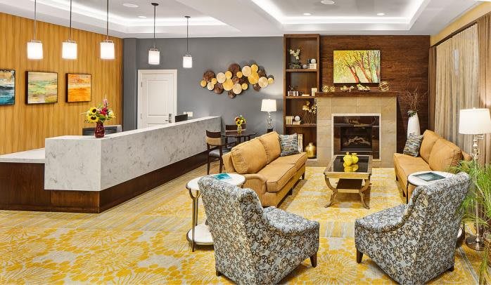 A stylishly designed living room with a sofa, chairs, fireplace, and decorative artwork.