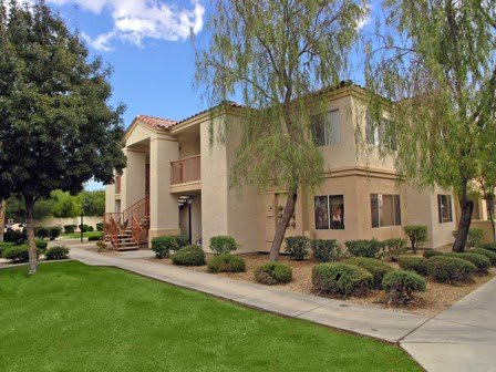 A well-maintained apartment complex with landscaped surroundings on a sunny day.