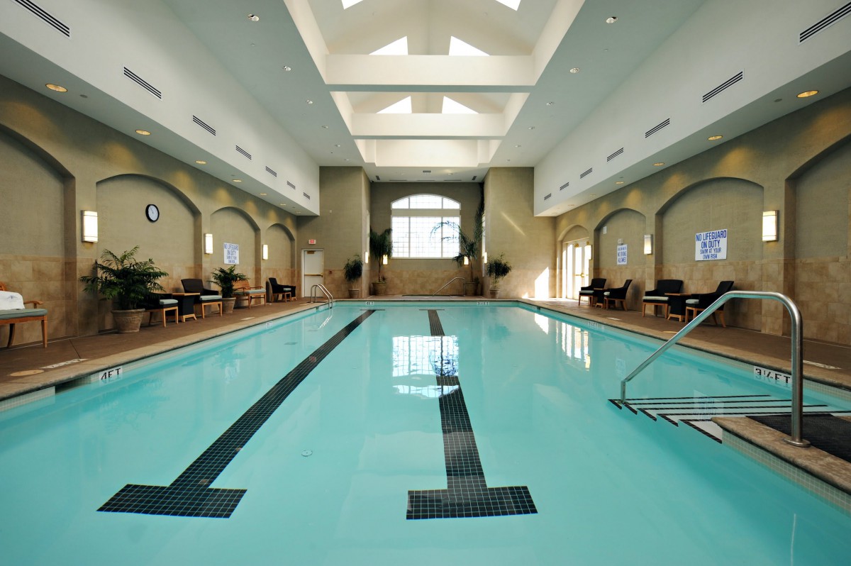 A serene indoor swimming pool with lanes for lap swimming, surrounded by elegant architecture.