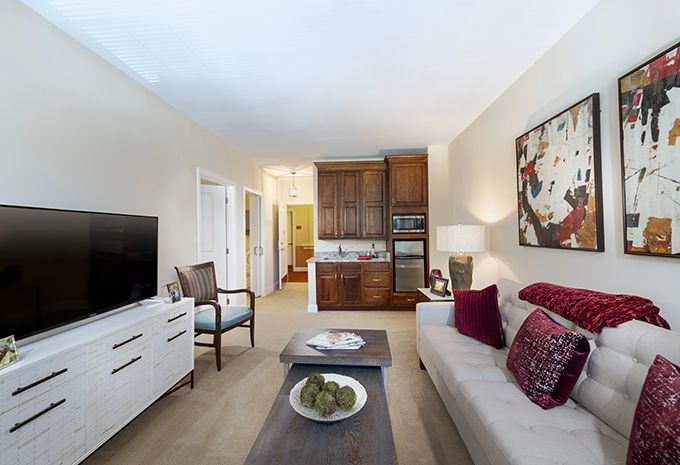 A cozy living room with modern decor, featuring a comfortable sofa, a television, and stylish artwork on the wall.