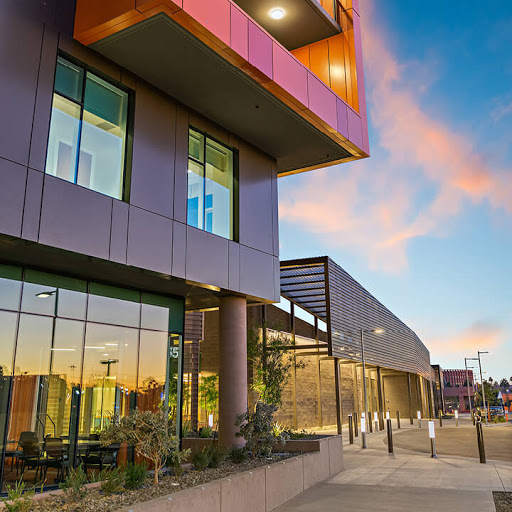 A modern building reflecting the colors of the sunset.