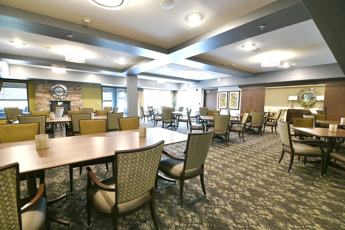 A spacious dining area with neatly arranged tables and chairs, well-lit with overhead lights.