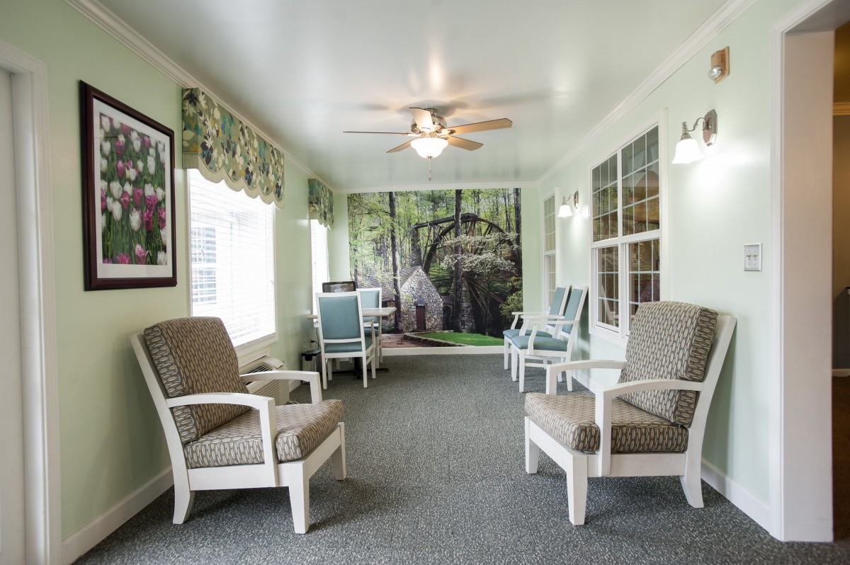 A cozy living space featuring comfortable seating, a ceiling fan, and scenic wall art.