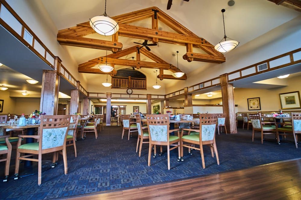 Spacious dining area with wooden beams and elegant chandeliers.