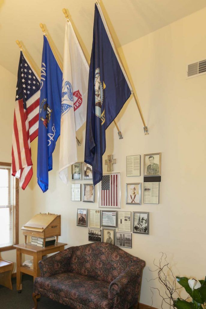 A display of multiple flags, including the American flag, in a museum setting.