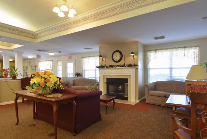 A cozy living room with a fireplace, sofas, and elegant decor.