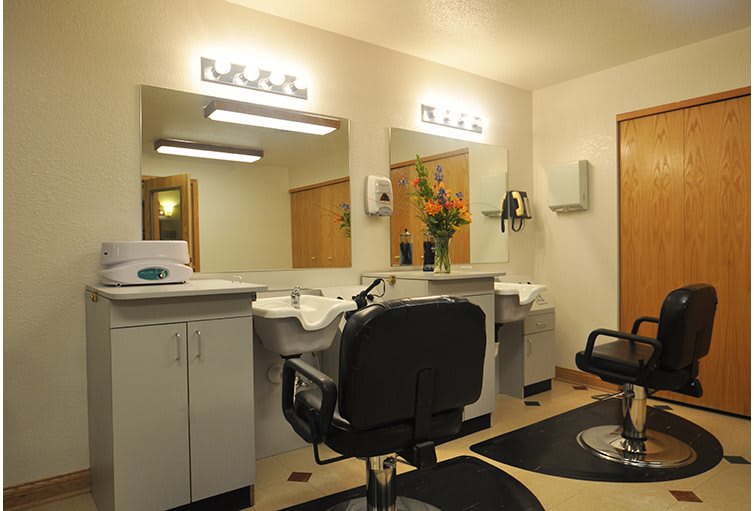 Interior of a modern hair salon with chairs and mirrors.