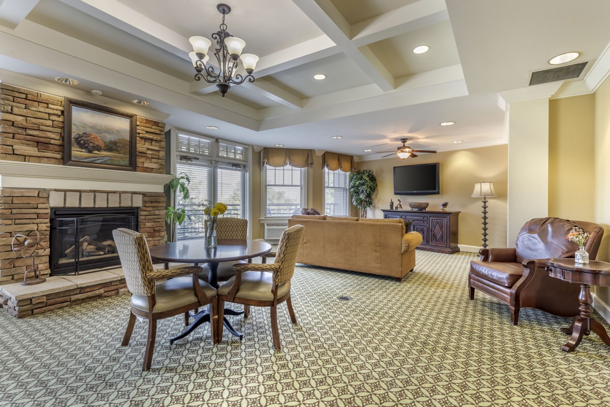 Cozy living room with elegant decor, featuring a fireplace, comfortable seating, and a large television.