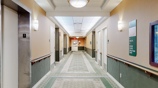 A view of a well-lit hotel hallway leading to the reception area.