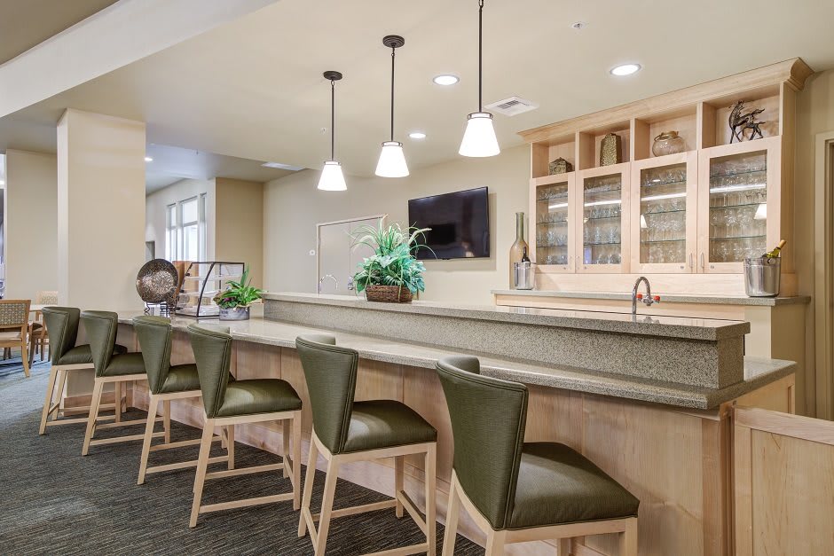 A modern home bar with a sleek countertop and stylish stools.