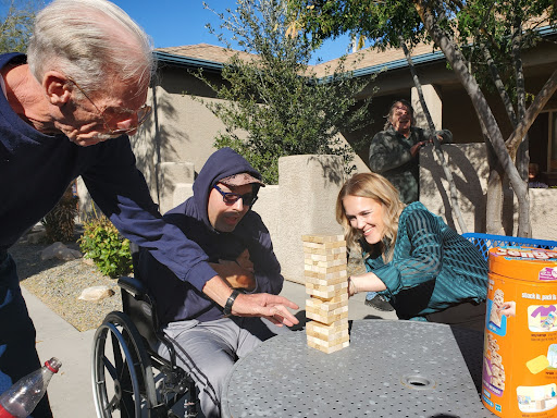 A joyful moment as family members engage in a game of Jenga outdoors.
