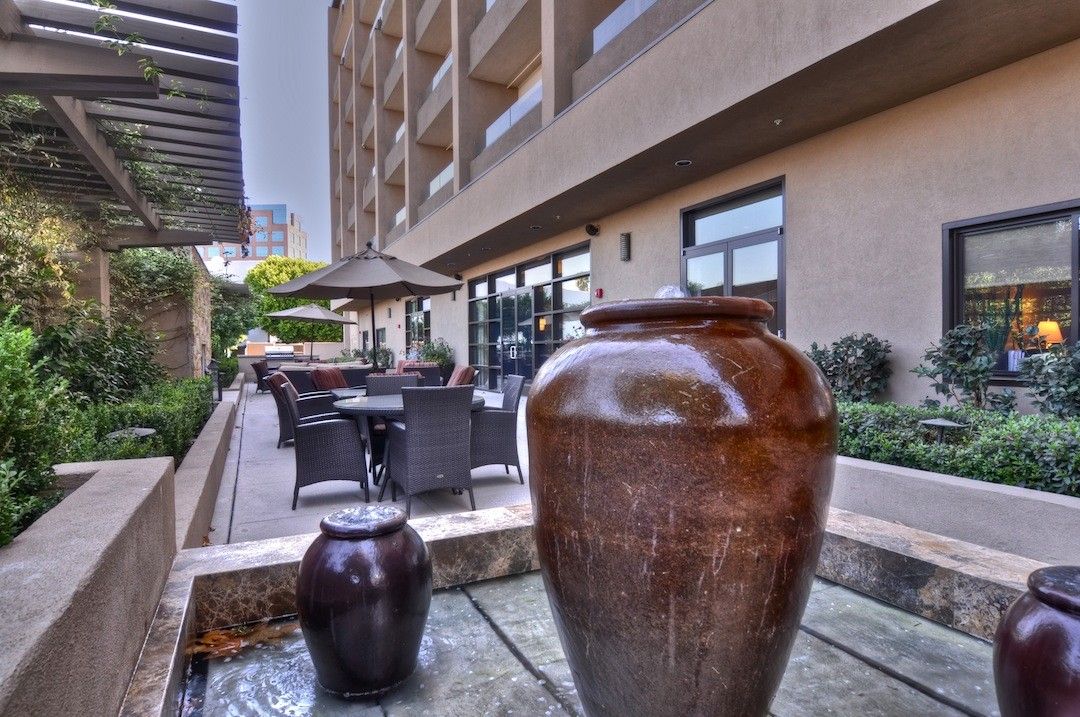 A spacious outdoor patio area with large decorative pots and seating arrangements near a building exterior.