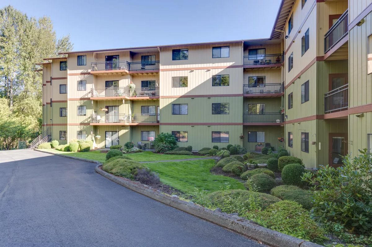 A residential apartment building with well-maintained landscaping and balconies.