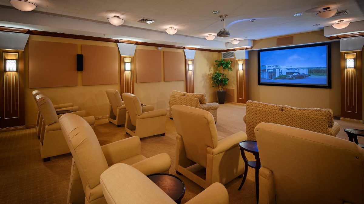 A cozy home theater setup with comfortable recliner seats and a large projector screen.