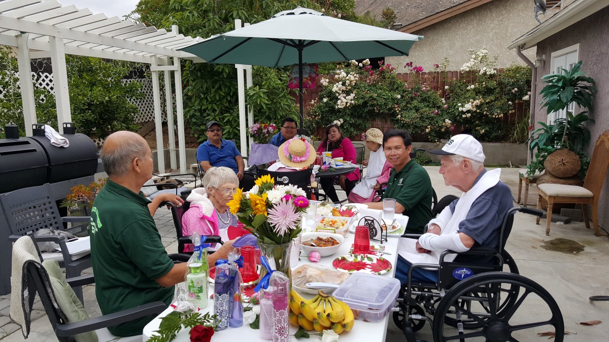 A group of people enjoying an outdoor gathering with food and decorations.