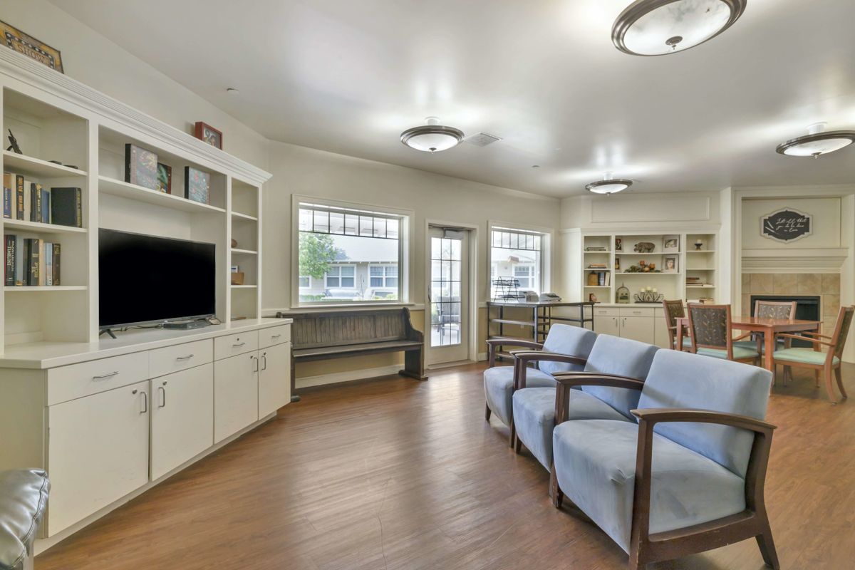 A modern living room with comfortable seating, a television, and built-in bookshelves.