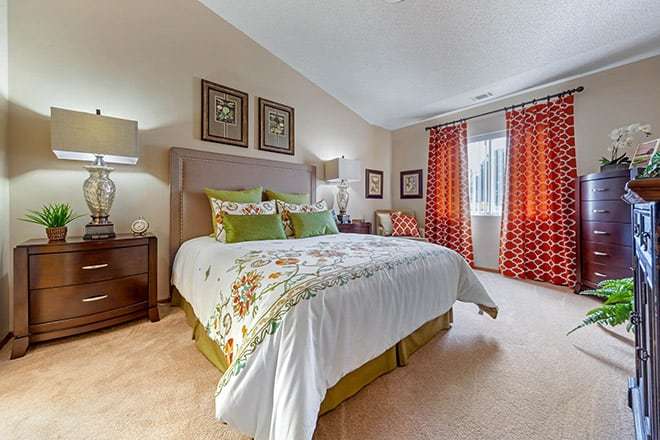 A cozy bedroom with a large bed, vibrant curtains, and elegant decor.