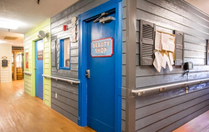 A colorful hallway in a children's hospital with a bright blue door labeled 'Beach Shack'.