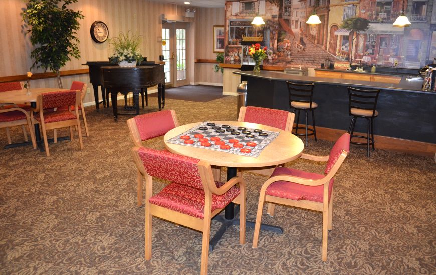 A cozy lounge area with a checkers set on the table and comfortable seating, adjacent to a counter.