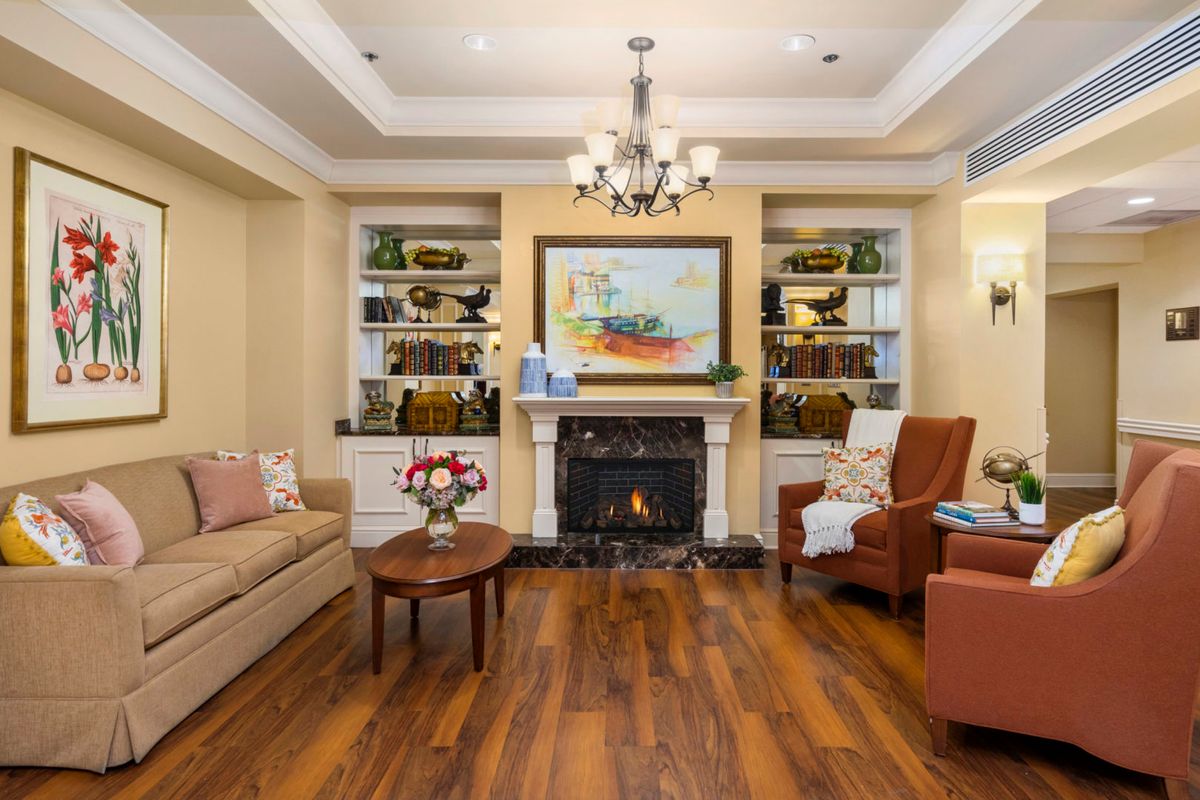 A cozy living room with a fireplace, chandelier, and comfortable seating.