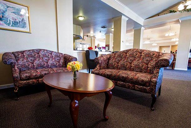 A cozy living room with floral-patterned sofas and a wooden coffee table.