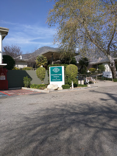 A view of a residential building with prominent signage surrounded by trees and a clear sky.