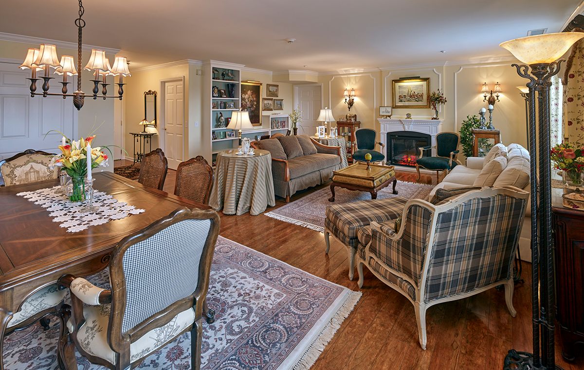 A cozy, traditionally decorated living room with elegant furniture and a fireplace.
