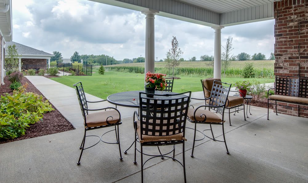A tranquil patio with outdoor seating overlooking a lush green landscape.
