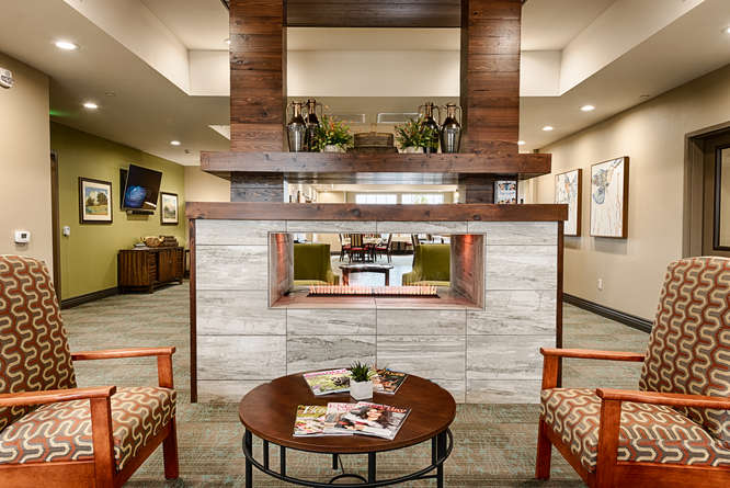 A modern lobby with a central fireplace and comfortable seating.