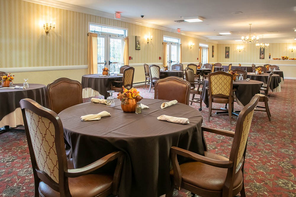 A formal dining room setup with round tables and upholstered chairs.